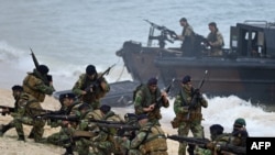 FILE - Portuguese Fuzileiros secure the area after disembarking from an amphibious transport during an exercise as part of NATO's Trident Juncture 2015 in Troia, 100 kms south of Lisbon, Nov. 5, 2015. 