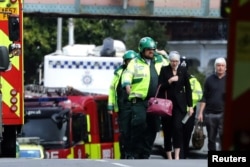 An injured woman is led away after an incident at Parsons Green underground station in London, Britain, Sept. 15, 2017.