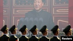 Xitoy Ozodlik armiyasi askarlari Prezident Si Zinpinning ulkan portreti oldida, Pekin, Xitoy, 2019-yil, 1-oktabr.