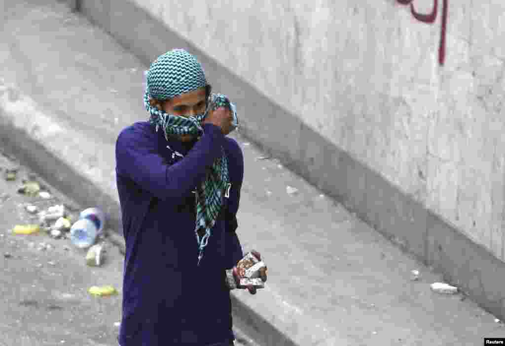 A protester carries stones to throw at the police during clashes near Tahrir Square, Cairo, Egypt, November 28, 2012.