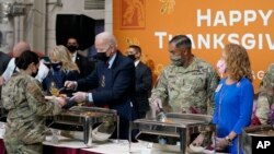 Presiden Joe Biden dan ibu negara Jill Biden melayani para tentara dengan sajian makan malam saat berkunjung ke Fort Bragg pada 22 November 2021, untuk menandai perayaan hari libur Thanksgiving. (Foto: AP/Evan Vucci)