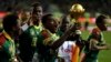 Cameroon players run celebrating with the trophy after winning the African Cup of Nations final soccer match between Egypt and Cameroon at the Stade de l'Amitie, in Libreville, Gabon, Sunday, Feb. 5, 2017. 