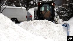 Un hombre recoge nieve el lunes, 28 de enero, de 2019, en Wheeling, Illinois, después que una tormenta de invierno dejó más de 12,7 centímetros de nieve en la zona.