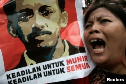 Seorang pengunjuk rasa meneriakkan slogan-slogan sambil menunjukkan foto mendiang aktivis HAM, Munir Said Thalib, dalam demonstrasi di luar kantor Badan Intelijen Nasional (BIN), di Jakarta, 7 September 2007.