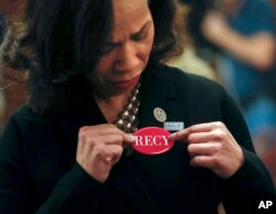 Democratic Rep. Lisa Blunt Rochester of Delaware adjusts her "RECY" button as she joins other House members in wearing black in support the metoo and timesup movement, ahead of tonight's State of the Union address on Capitol Hill in Washington, Jan. 30, 2018. Members of the Congressional Black Caucus and members of the Democratic Caucus wore red pins in memoriam of Recy Taylor. Taylor was abducted and raped while walking home from work in Alabama in 1944.