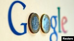 FILE - An illustration picture shows a Google logo with two one Euro coins, taken in Munich.