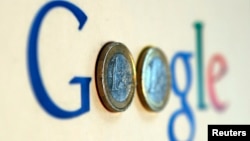 FILE - An illustration picture shows a Google logo with two one Euro coins.