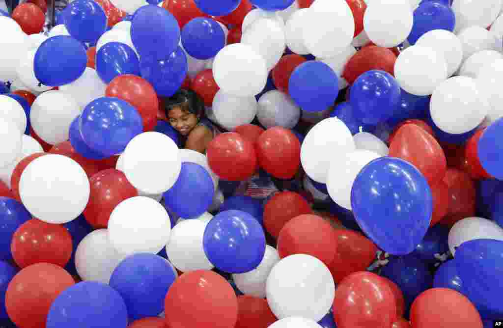 Karla Ortiz, 11, of Las Vegas, dives into balloons on the floor after the Democratic National Convention in Philadelphia.