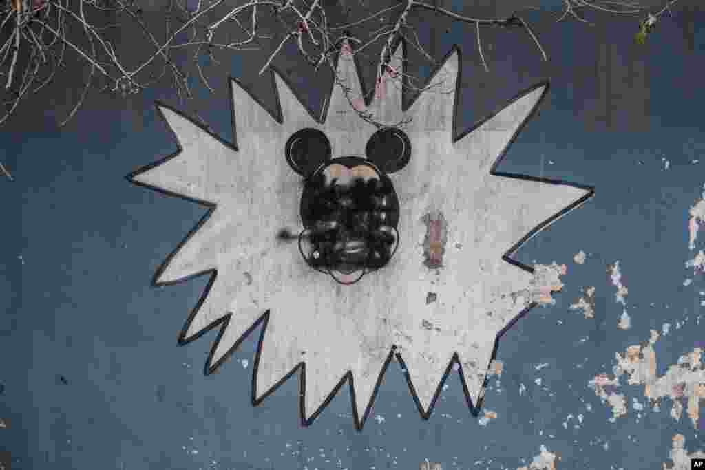 This Sunday, Dec. 18, 2016 photo shows a drawing of Mickey Mouse with its face painted over by Islamic States militants on the wall of a kindergarten n the al-Barid district in Mosul, Iraq.