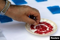 FILE - An unidentified official holds up a yaba tablet, seized by Myanmar's police, during a news conference in Laukkai, capital of Myanmar's Kokang region, Sept. 8, 2009. On the drug market, one pill costs costs no more than $3 to $4.