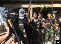 FILE - Iraqi Shiite Turkmen gunmen gather as they prepare to patrol around the village of Taza Khormato in the northern oil rich province of Kirkuk, Iraq, June 20, 2014.