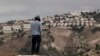یکی از ساکنان «معاله آدومیم» در حال نگاه کردن به این بزرگترین شهرک یهودی نشین اسرائیلی واقع در کرانه باختری - ۵ دسامبر ۲۰۱۲ 