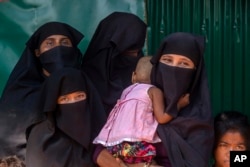 Rohingya Muslim women along with their children, who have crossed over from Myanmar into Bangladesh, wait for the arrival of Queen Rania of Jordan, at Kutupalong refugee camp in Bangladesh, Oct. 23, 2017.