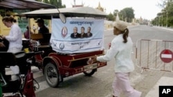 An election campaign poster of Prime Minister Hun Sen's ruling Cambodian People's Party hangs on the back of a motorized rickshaw parked at a blocked street in front of the Royal Palace in Phnom Penh.