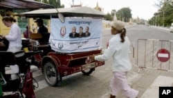 An election campaign poster of Prime Minister Hun Sen's ruling Cambodian People's Party hangs on the back of a motorized rickshaw parked at a blocked street in front of the Royal Palace in Phnom Penh.