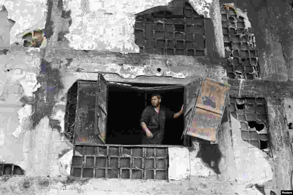 A worker looks out of the severely damaged al-Awdah food factory in Deirl al-Balah in the central Gaza Strip, Aug.14, 2014.