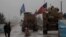 A line of US military vehicles drive through a checkpoint of the Internal Security Forces in Manbij as they head to their base on the outskirts of the northern Syrian city on December 30, 2018.