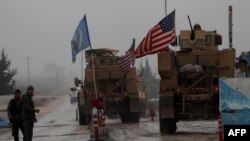 Kendaraan militer pasukan AS siaga di sebuah tempat pemeriksaan di kota Manbij, Suriah utara (30/12). 
