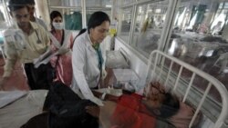 A doctor attends to a hepatitis patient in a special isolation area at a hospital in Ahmadabad, India