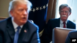 FILE - National security adviser John Bolton listens as President Donald Trump speaks during a cabinet meeting at the White House in Washington, April 9, 2018.