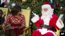 Santa Claus gestures toward first lady Michelle Obama, at Children's National Medical Center in Washington