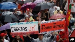 Demonstrators march against Brazil's President Michel Temer, holding banners that reads in Portuguese "Temer Out", and "Elections Now", in Sao Paulo, Brazil, May 21, 2017.