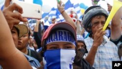 La gente participa en una manifestación llamada "Marcha de las Flores" que recuerda a los niños asesinados durante los últimos dos meses de violencia en Managua.