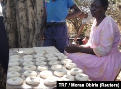 A woman sells doughnuts at an open-air bakery in Arubela, Uganda, Feb. 14, 2018.