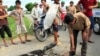 Cư dân vây quanh một chiếc xe máy bị cháy thành than trong tỉnh Nghệ An. Dân làng phẫn nộ vì bị trộm chó đã thu giữ xe máy của các tên trộm chó và nổi lửa đốt xe.