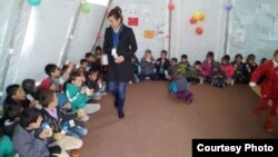 Lilah Salih, a Yazidi woman from a village outside Sinjar in northern Iraq, resettled in the U.S. with her husband in 2017. She is pictured here working Yazidi children when she was in the Sharia refugee camp after the attack on Sinjar.
