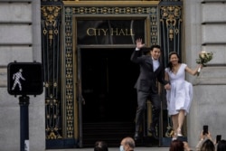A couple reacts after getting married at City Hall in downtown San Francisco, California, October 22, 2021.