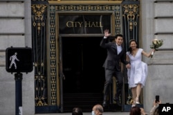 Sepasang suami istri setelah menikah di City Hall di pusat kota San Francisco, California, 22 Oktober 2021. (Foto: REUTERS/Carlos Barria)