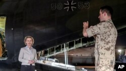 FILE - German Defense Minister Ursula von der Leyen poses in front of a German Air Force plane in Amman, Jordan, Sept. 21, 2016, on her way to Iraq.