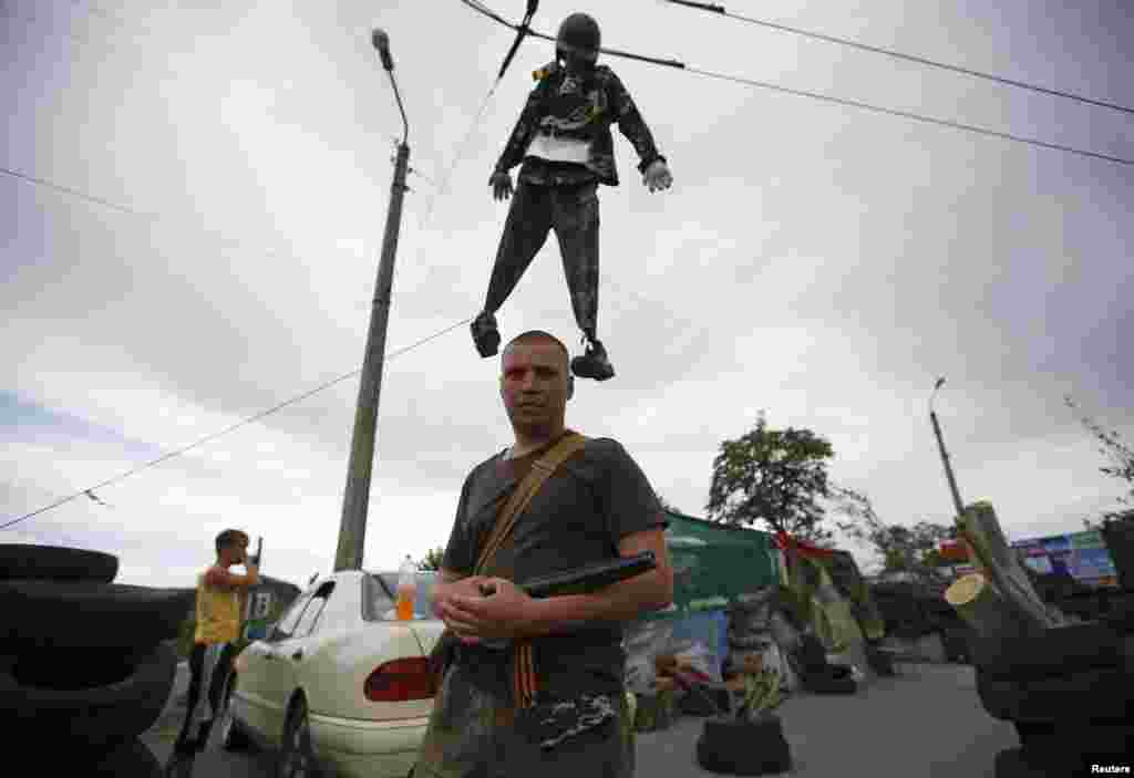 A pro-Russian man with a black and orange ribbon of St. George attached to his weapon stands in Slovyansk, Ukraine, May 23, 2014.