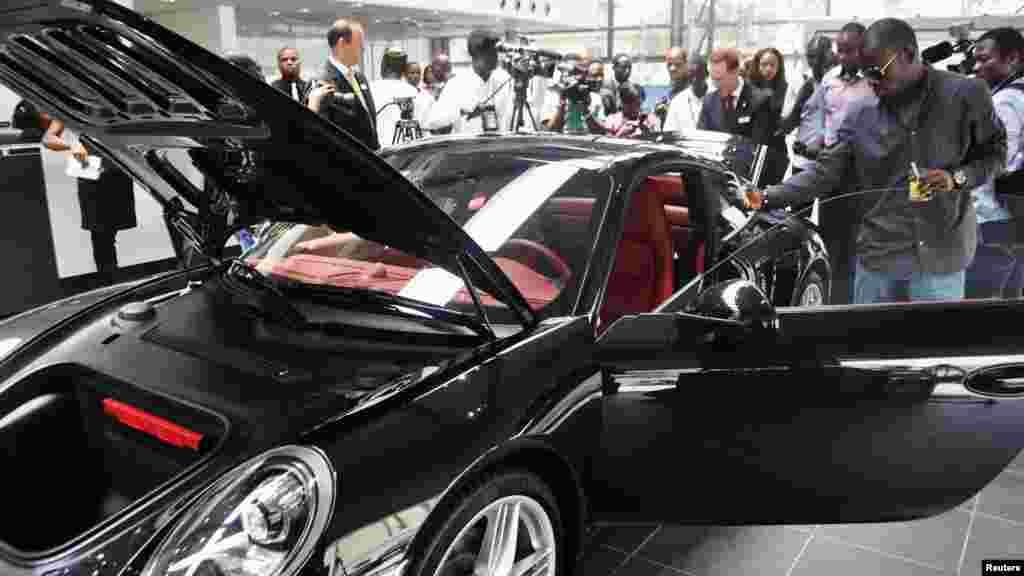 Nigerians look at a vehicle by German carmaker Porsche in Lagos, Nigeria.