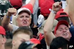 President Donald Trump supporters shake their fists at the media as Trump formally announced his 2020 re-election bid, June 18, 2019, in Orlando, Florida.