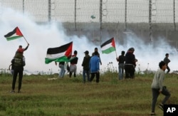 Izraelski vojnici bacaju suzavac na palestinske demonstrante na pojasu Gaze, 30. marta 2019.