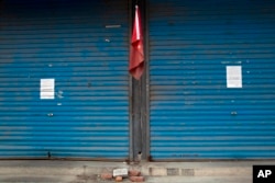 Eviction notices are pasted on shuttered stores near a Chinese national flag on the outskirts of Beijing, Nov. 27, 2017.