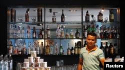 FILE - An employee works behind a bar at a restaurant in Phnom Penh, Cambodia, October 18, 2018.