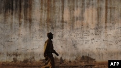 FILE - A prison guard walks along a perimeter wall at a prison in Rumbek, Lakes state, South Sudan, Feb. 19, 2014. Supporters are calling for the release of 32 prisoners detained in South Sudan allegedly for opposing the government of President Salva Kiir.