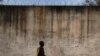 FILE - A prison guard walks along a perimeter wall at a prison in Rumbek, Lakes State, South Sudan, Feb. 19, 2014. 