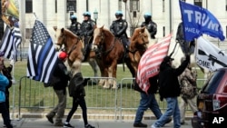 Members of the Albany police department mounted unit offer a police presence as gun rights activists with the National Constitutional Coalition of Patriotic Americans take part in a national rally aimed at pushing back against calls for stronger gun control measures outside the state Capitol, April 14, 2018, in Albany, New York.