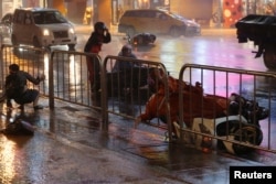 A man and motorcyclist fall as Typhoon Nesat hits Taipei, Taiwan, July 29, 2017.