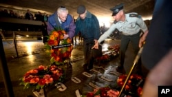 Holocaust survivors and their relatives lay a wreath next to the names of concentration camps during a ceremony marking the annual Holocaust Remembrance Day in Jerusalem, April 16, 2015.