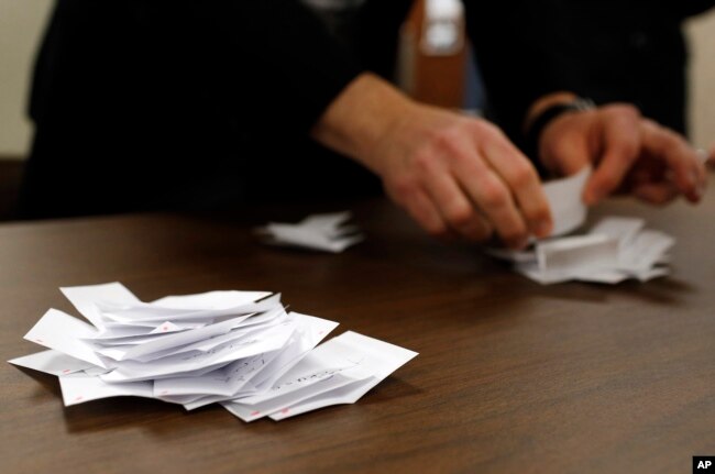 FILE - Precinct chair John Anderson counts votes for Republican candidates during a caucus in Nevada, Iowa, Monday, Feb. 1, 2016.