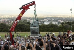 FILE - Students cheer as the statue of Cecil John Rhodes is removed from the University of Cape Town (UCT) in South Africa, April 9, 2015.