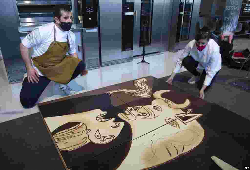 Members of Euskal Gozogileak (Basque Confectioners) association work on a life-size chocolate version of Picasso&#39;s painting &quot;Guernica&quot; in the Spanish Basque town of Lezo.