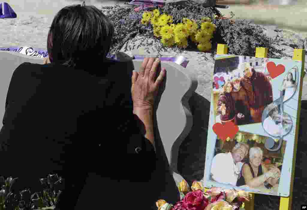 A woman mourns in front of a memorial site for the victims of the earthquake, in Amatrice, central Italy, a year after a deadly quake hit the area leaving nearly 300 people dead.