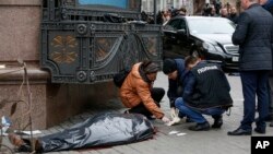 Forensic experts and police officers examine the scene following the killing of Denis Voronenkov in Kiev, Ukraine, March 23, 2017. 