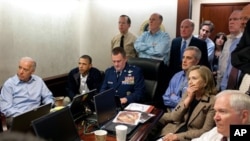 In this image released by the White House and digitally altered by the source to diffuse the paper in front of Secretary of State Hillary Rodham Clinton, President Barack Obama and Vice President Joe Biden, along with with members of the national security